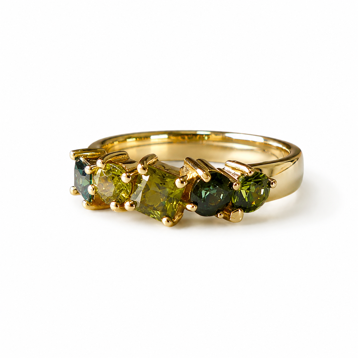 A yellow gold ring featuring three marquise-cut green gemstones in a row, set in a polished gold band against a plain white background.