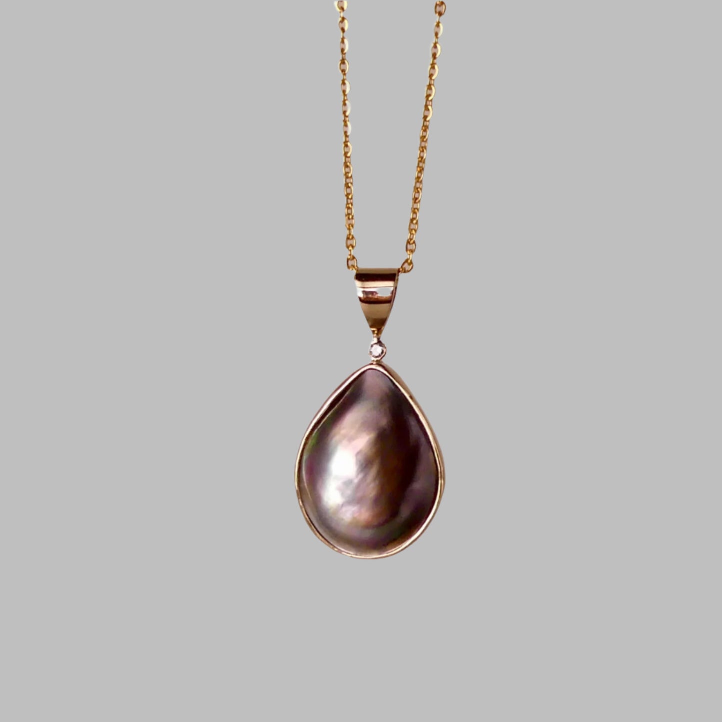 This Australian Abrolhos Island Mabe Black Pearl pendant, set in 9k gold, features a natural diamond accent that enhances its sophisticated allure. The rare Mabel black pearl’s rich, deep tones are beautifully complemented by the subtle sparkle of the diamond, creating a refined piece that exemplifies expert craftsmanship and distinctive Australian elegance.