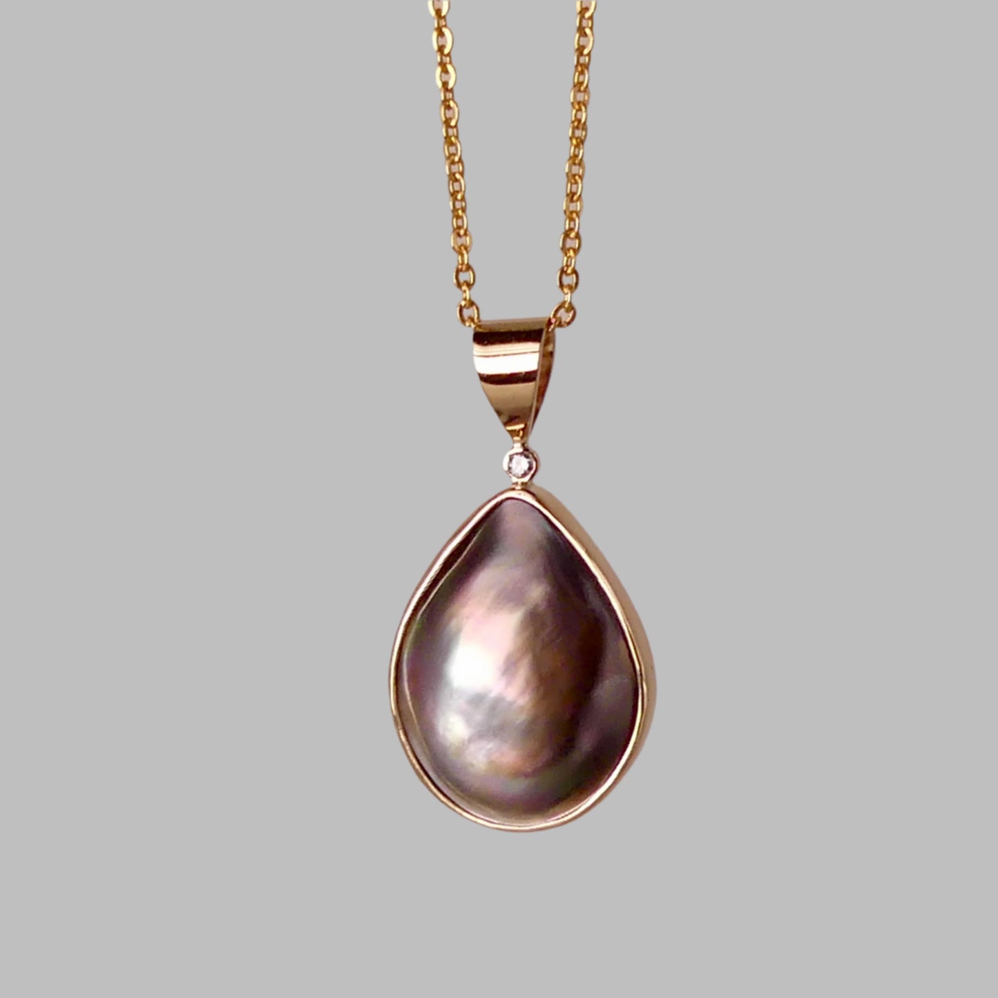 This Australian Abrolhos Island Mabe Black Pearl pendant, set in 9k gold, features a natural diamond accent that enhances its sophisticated allure. The rare Mabel black pearl’s rich, deep tones are beautifully complemented by the subtle sparkle of the diamond, creating a refined piece that exemplifies expert craftsmanship and distinctive Australian elegance.