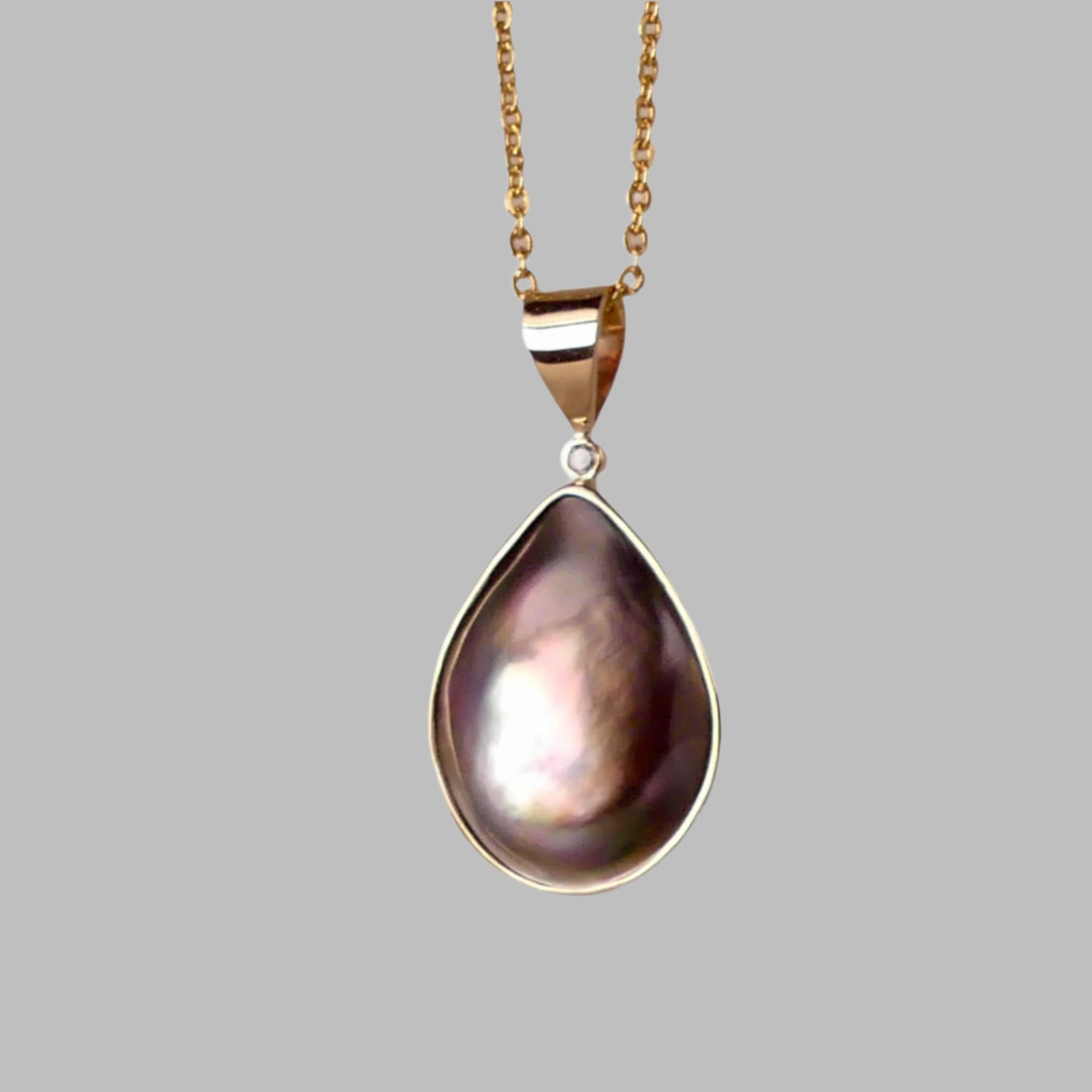 This Australian Abrolhos Island Mabe Black Pearl pendant, set in 9k gold, features a natural diamond accent that enhances its sophisticated allure. The rare Mabel black pearl’s rich, deep tones are beautifully complemented by the subtle sparkle of the diamond, creating a refined piece that exemplifies expert craftsmanship and distinctive Australian elegance.