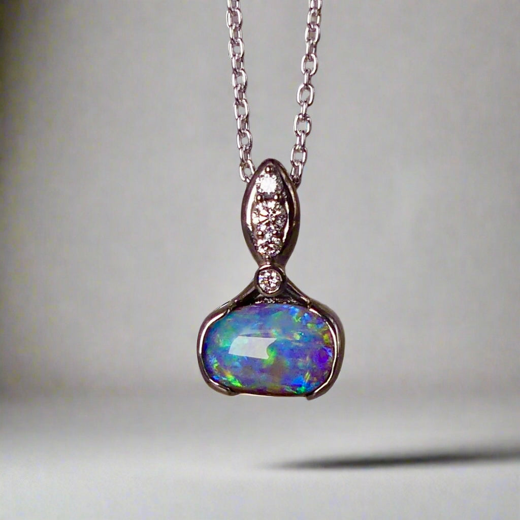 This exquisite pendant features a rare Australian Boulder Opal set in 18k white gold, expertly crafted to highlight the opal’s vibrant play of colors. Accented with natural diamonds, this statement piece that combines exceptional craftsmanship with the distinctive allure of genuine opal.