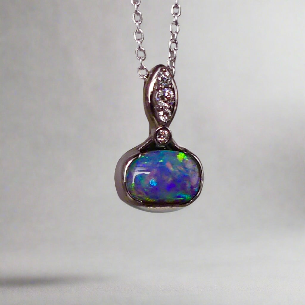 This exquisite pendant features a rare Australian Boulder Opal set in 18k white gold, expertly crafted to highlight the opal’s vibrant play of colors. Accented with natural diamonds, this statement piece that combines exceptional craftsmanship with the distinctive allure of genuine opal.