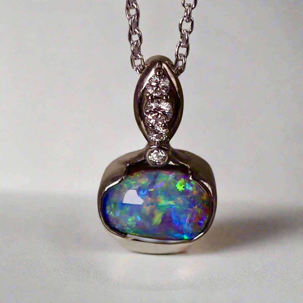 This exquisite pendant features a rare Australian Boulder Opal set in 18k white gold, expertly crafted to highlight the opal’s vibrant play of colors. Accented with natural diamonds, this statement piece that combines exceptional craftsmanship with the distinctive allure of genuine opal.