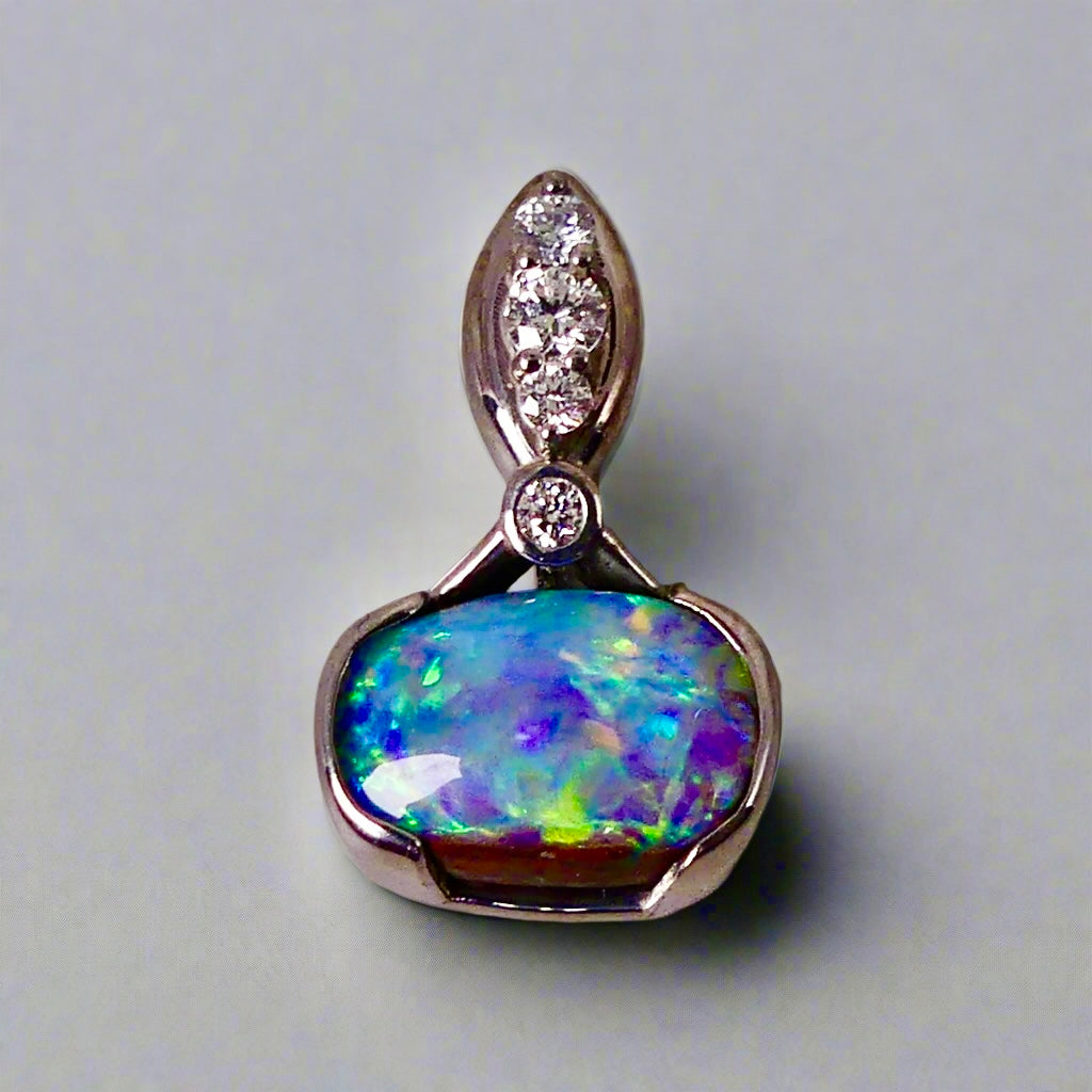 This exquisite pendant features a rare Australian Boulder Opal set in 18k white gold, expertly crafted to highlight the opal’s vibrant play of colors. Accented with natural diamonds, this statement piece that combines exceptional craftsmanship with the distinctive allure of genuine opal.