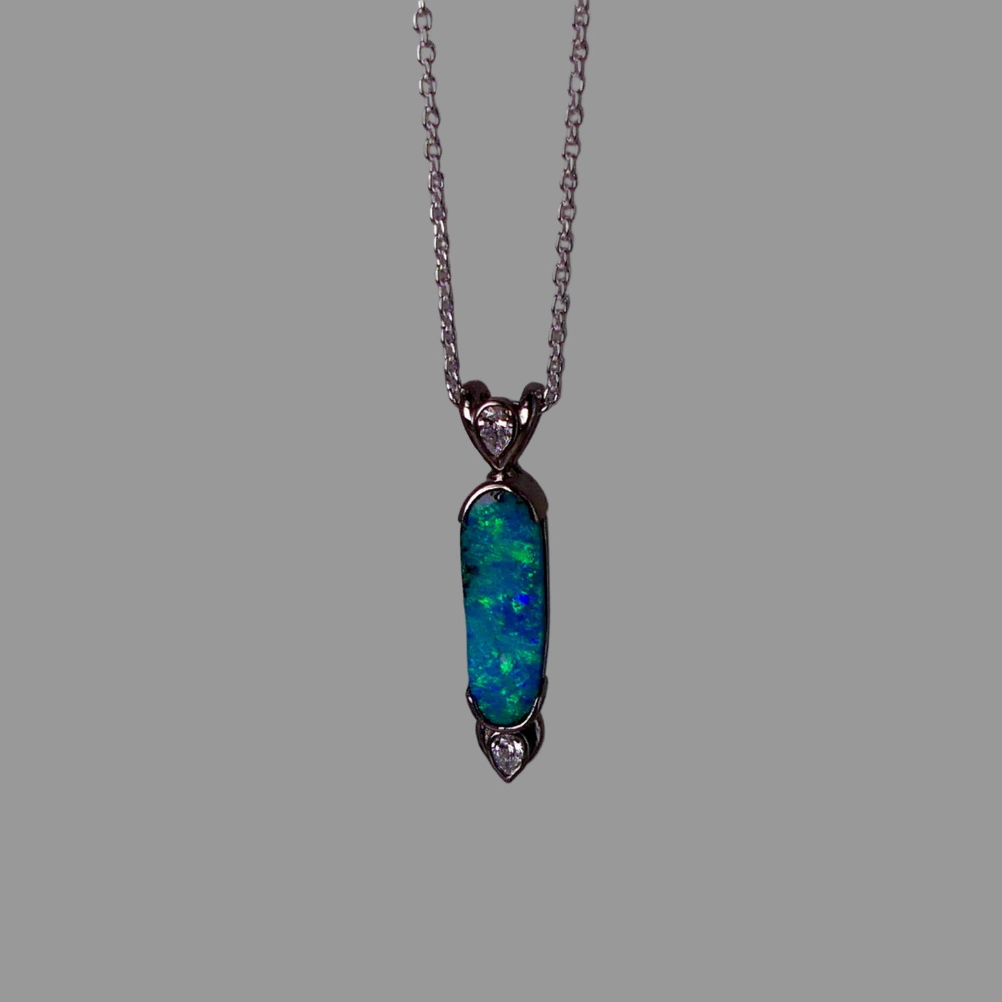 Opal pendant necklace on a gray background