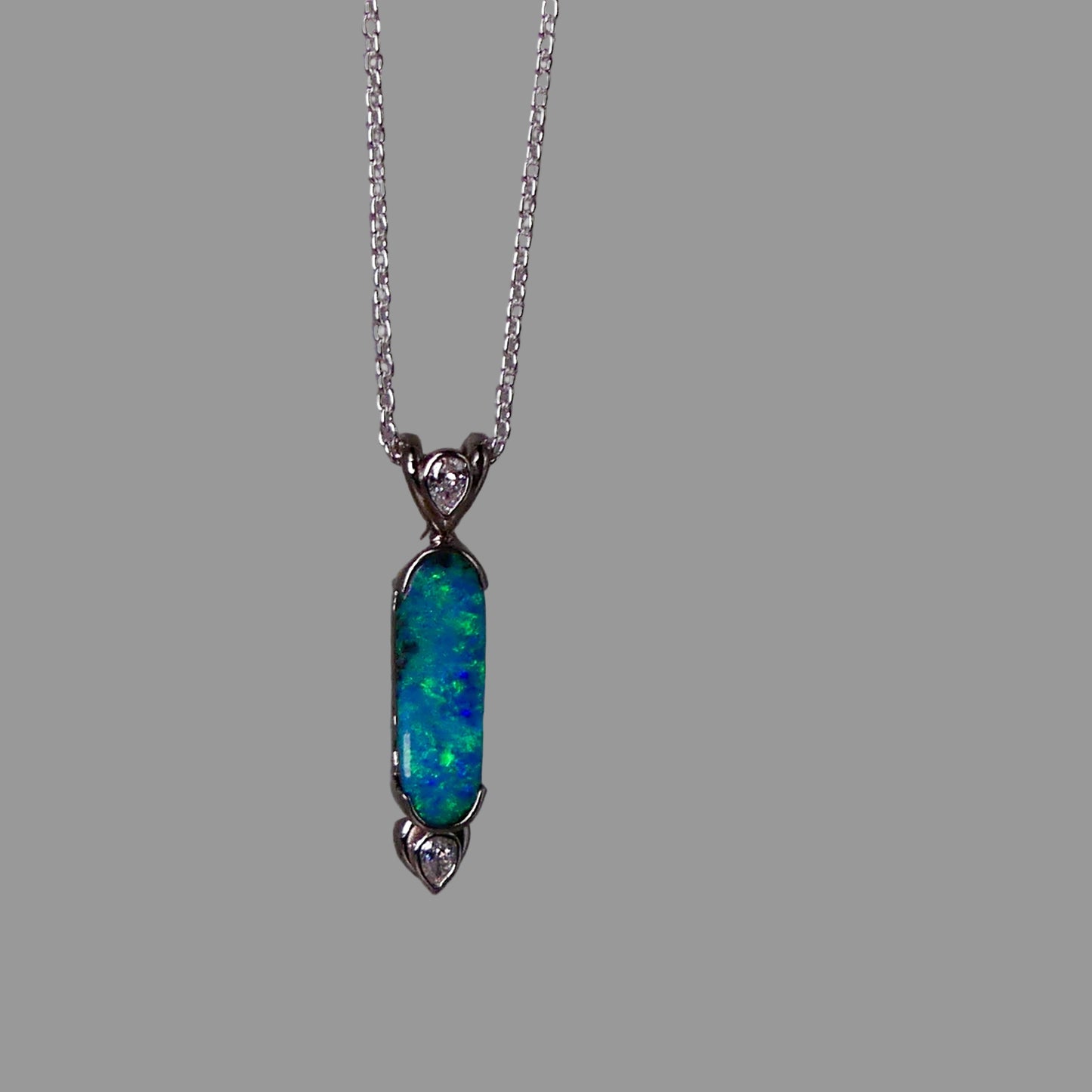 Opal pendant necklace on a gray background