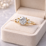 Gold diamond ring on a beige cushion in a jewelry box