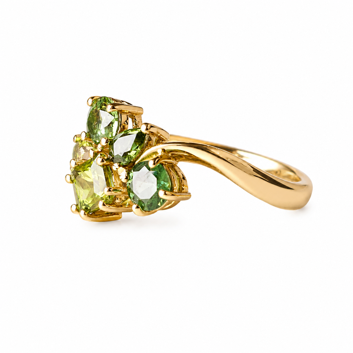 A yellow gold ring featuring a cluster of green gemstones, shown on a plain white background.