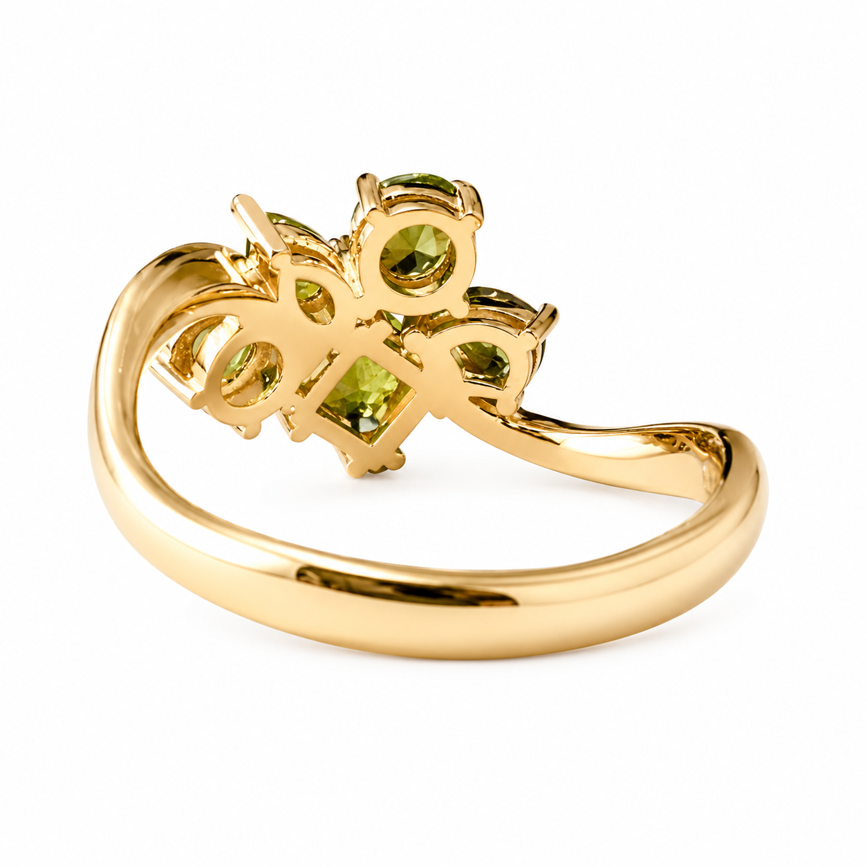 A gold ring featuring a decorative openwork floral or butterfly-like top set with green gemstones, shown on a plain white background.