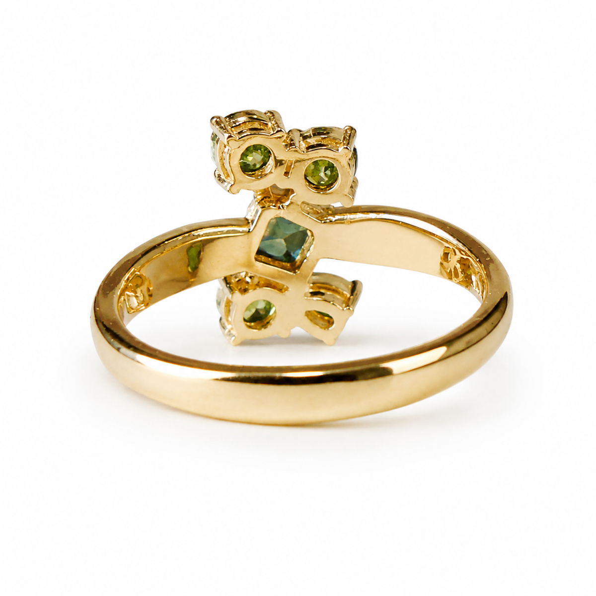 A yellow gold ring featuring a cluster of green gemstones, including a central dark green square-cut stone, two olive green oval stones, and two lime green pear-shaped stones, set against a plain white background.
