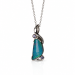 A silver pendant necklace featuring a teardrop-shaped blue-green opal stone with two small round purple gemstones, suspended from a delicate silver chain on a white background.