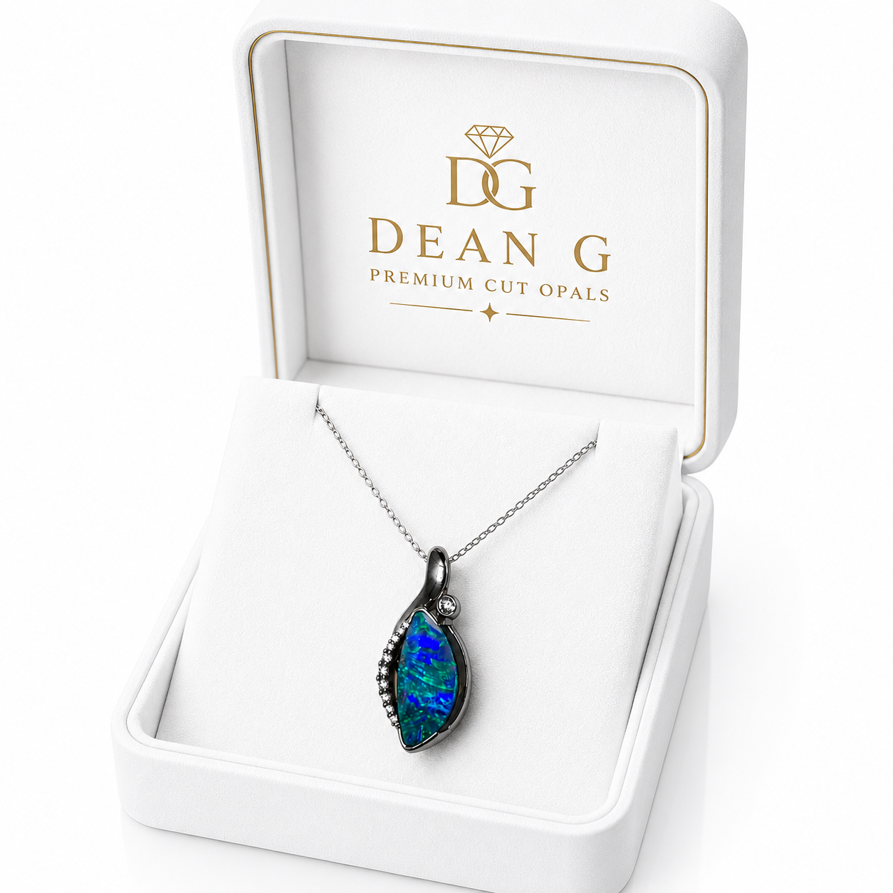 A teardrop-shaped cut opal pendant necklace with a dark metal setting, displayed inside an open white Dean G Premium Cut Opals gift box.