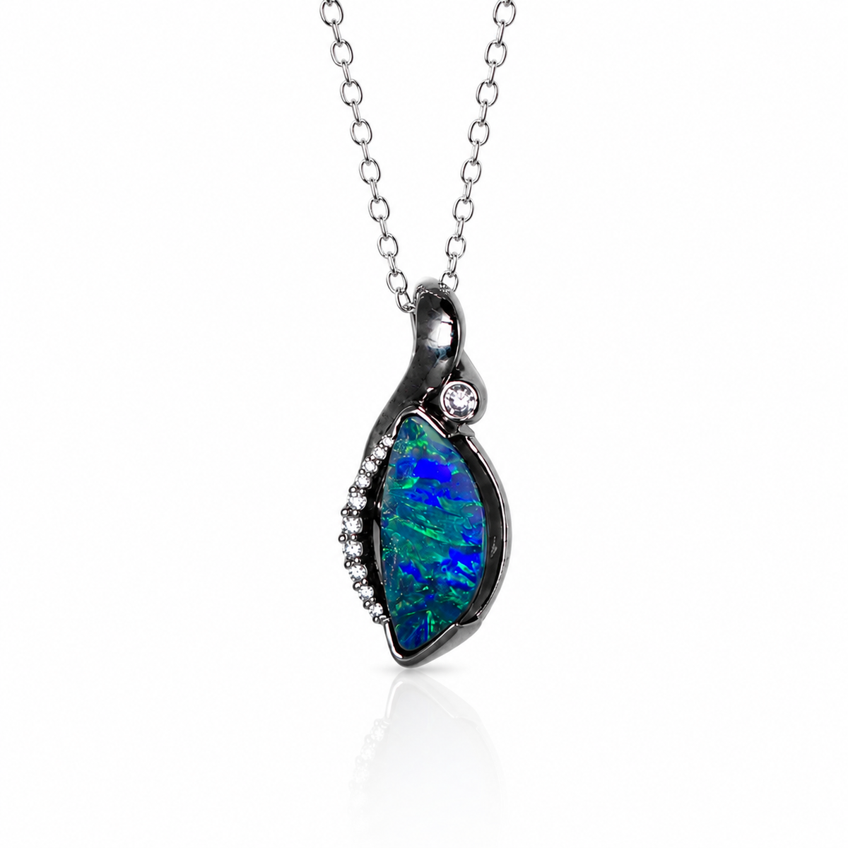 A silver pendant necklace featuring a teardrop-shaped opal stone with vibrant blue and green play-of-color, accented with small clear stones on a white background.
