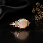 Gold ring with a colorful opal stone on a dark background