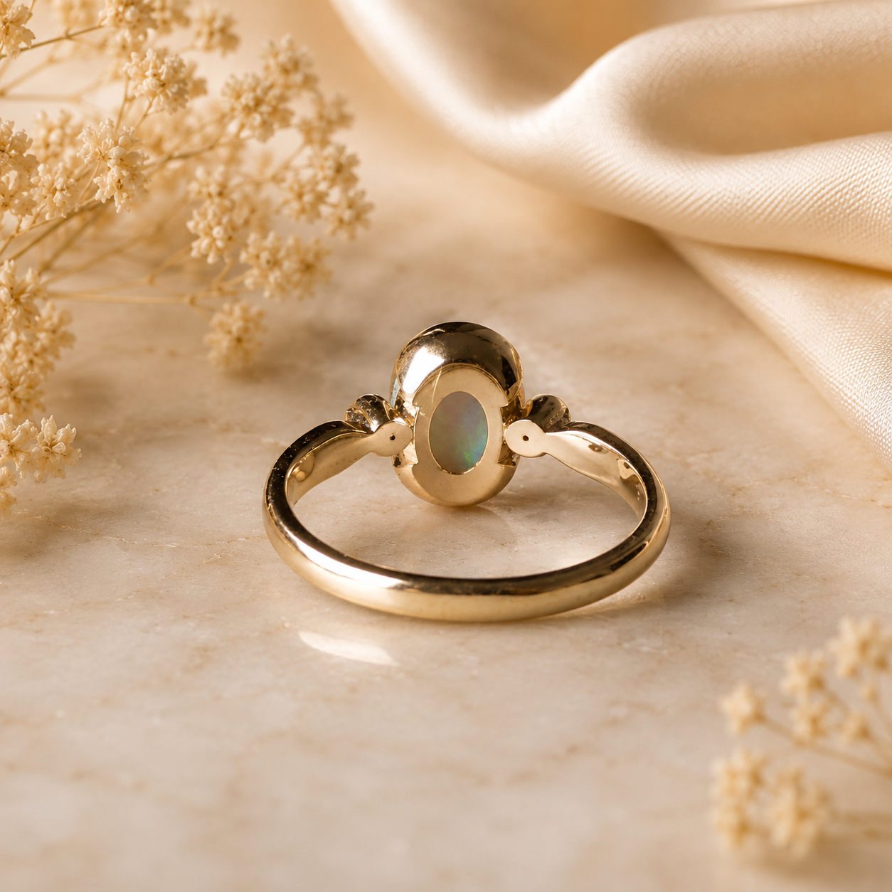 Gold ring with a central gemstone on a beige fabric background