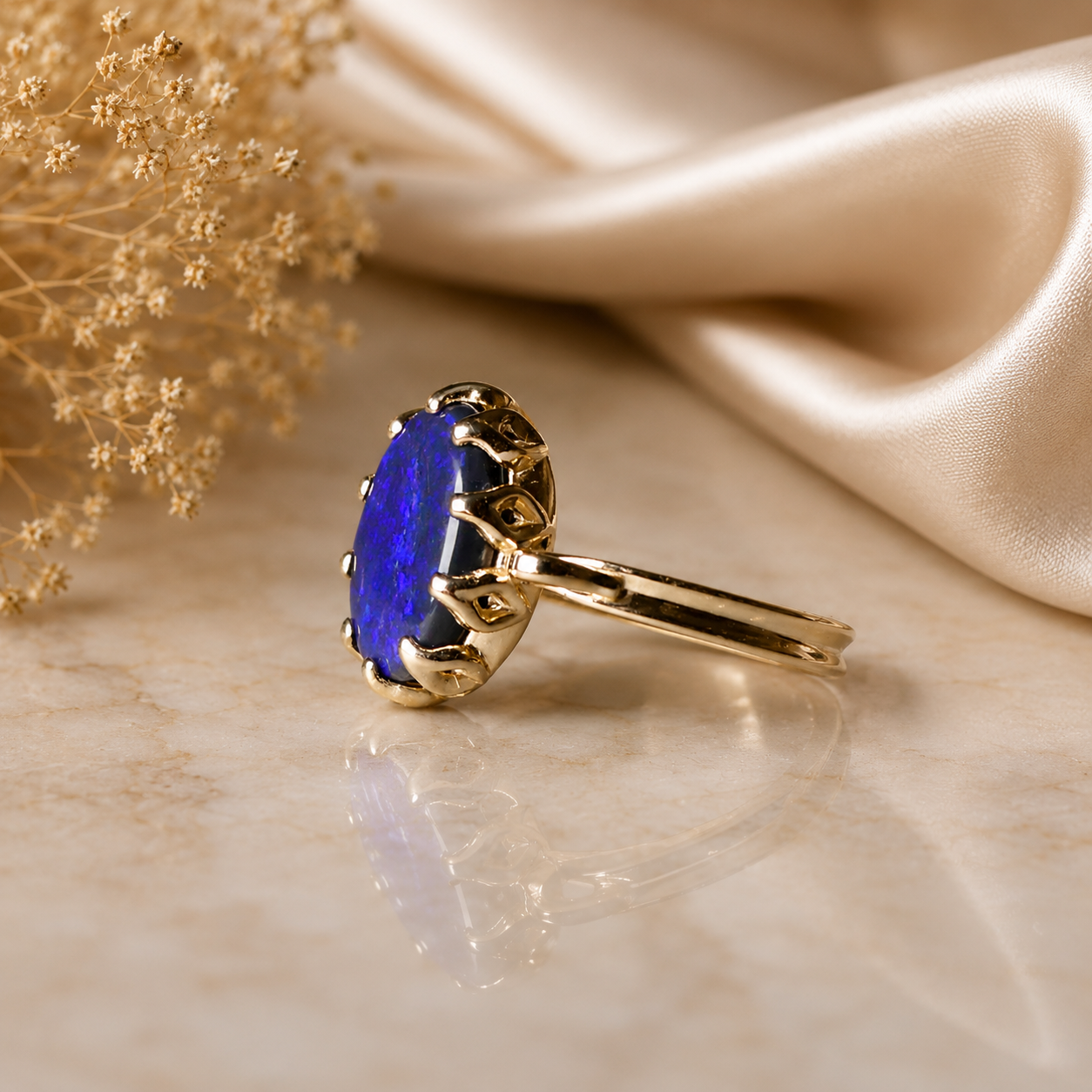 Gold ring with a blue gemstone on a beige fabric background