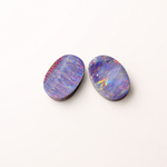 Two colorful opal stones on a white background