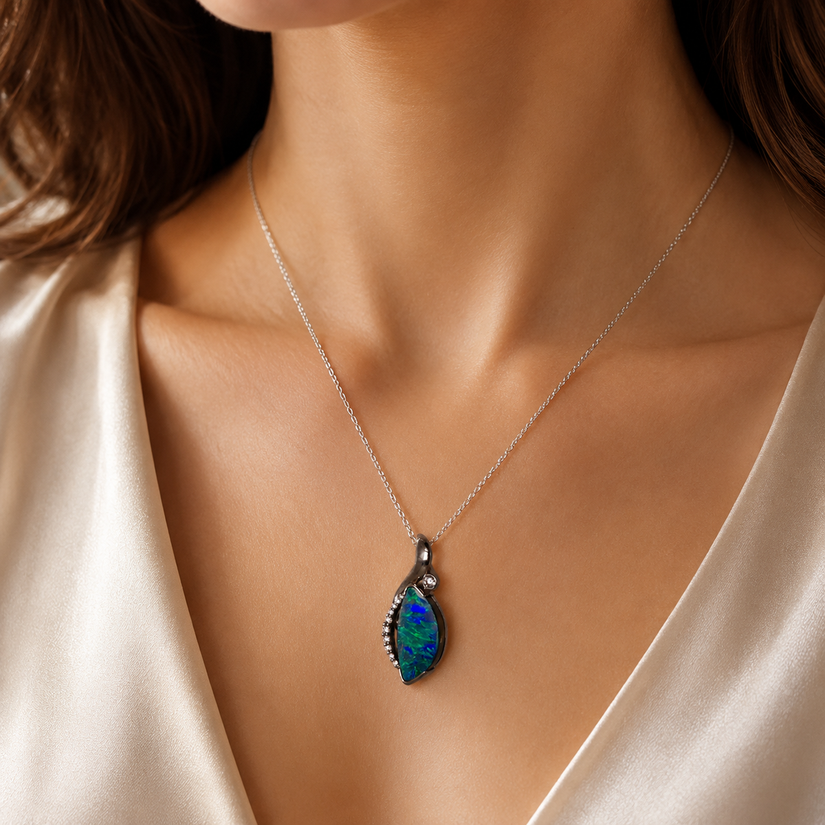 Necklace with a blue pendant worn by a person against a neutral background
