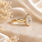 Gold ring with a large diamond on a soft beige background