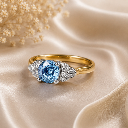 Gold ring with a blue gemstone on beige satin fabric
