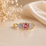 Gold ring with a pink gemstone on a soft beige background