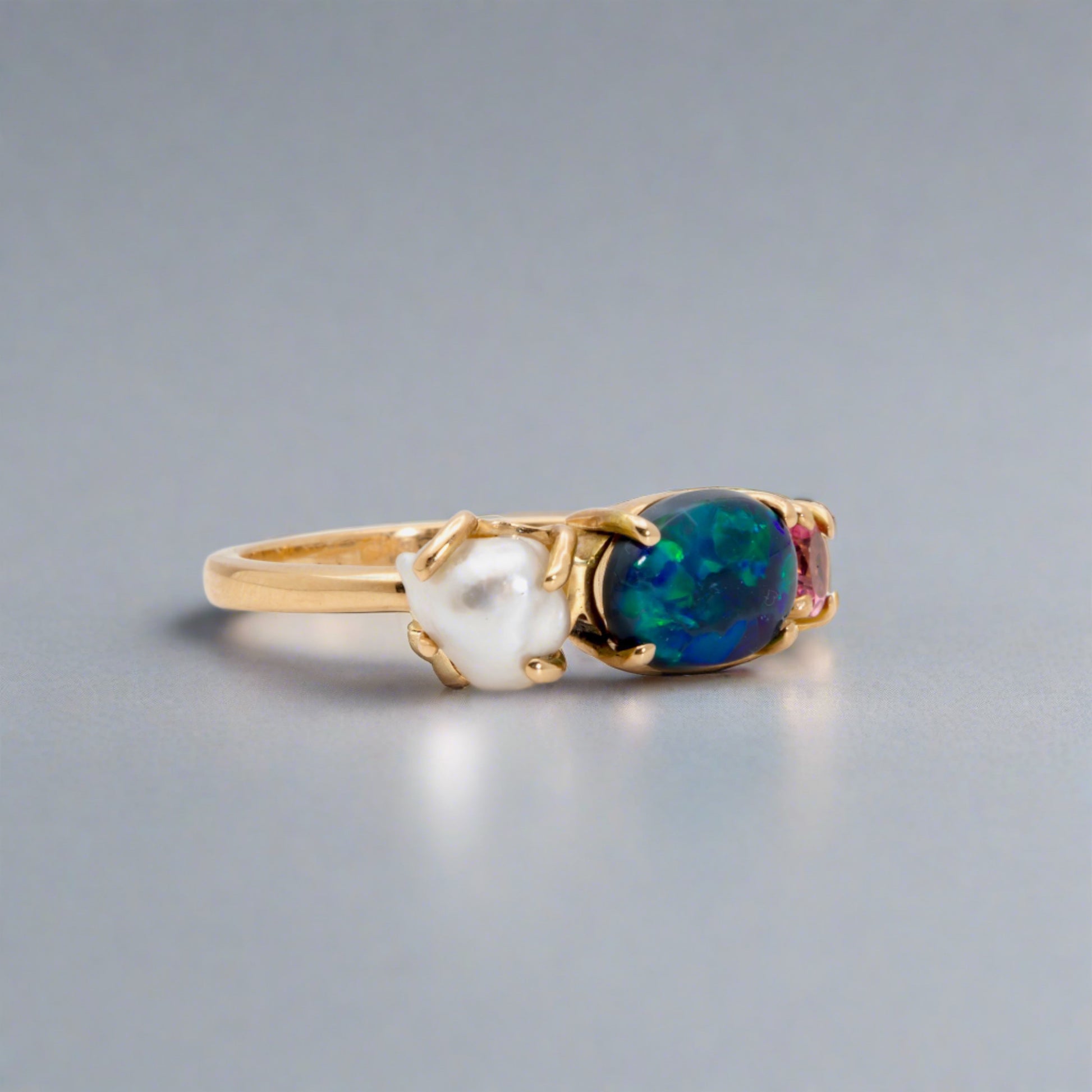Introducing our stunning Seascapes Collection! This 14k gold ring perfectly captures the beauty and harmony of nature's wonders. Handcrafted to perfection, it is the epitome of elegance.

Origin- Lightning Ridge Australia

Opal Weight- 1ct Australian Black Opal.

Setting- 14k Gold Claw Setting

Accent Stone- Pink Tourmaline

Pearl- Keshi Pearl

Size - 7us -

Handcrafted and designed by Australian Artisans