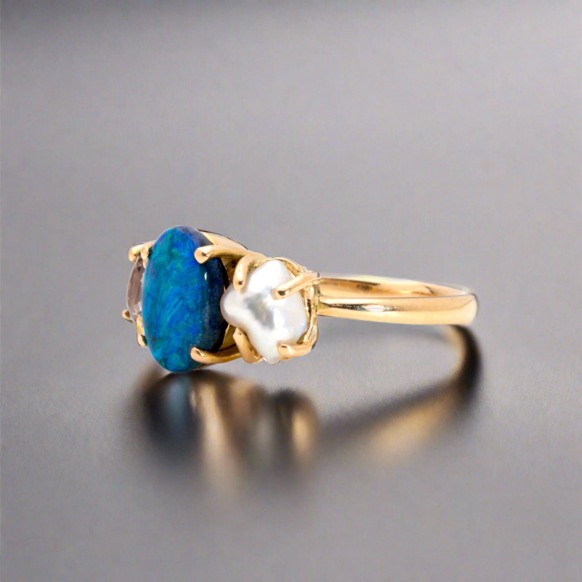Experience the stunning harmony of nature with our 14k gold Australian Black Opal ring from our Seascapes Collection.

Origin- Lightning Ridge Australia

Opal Weight- 1ct Australian Black Opal

Accent Stone - Mauve Tourmaline

Pearl- Keshi pearl

Setting- 14k gold claw

Ring Size - 6 1/2 us

Handcrafted and designed by Australian Artisians