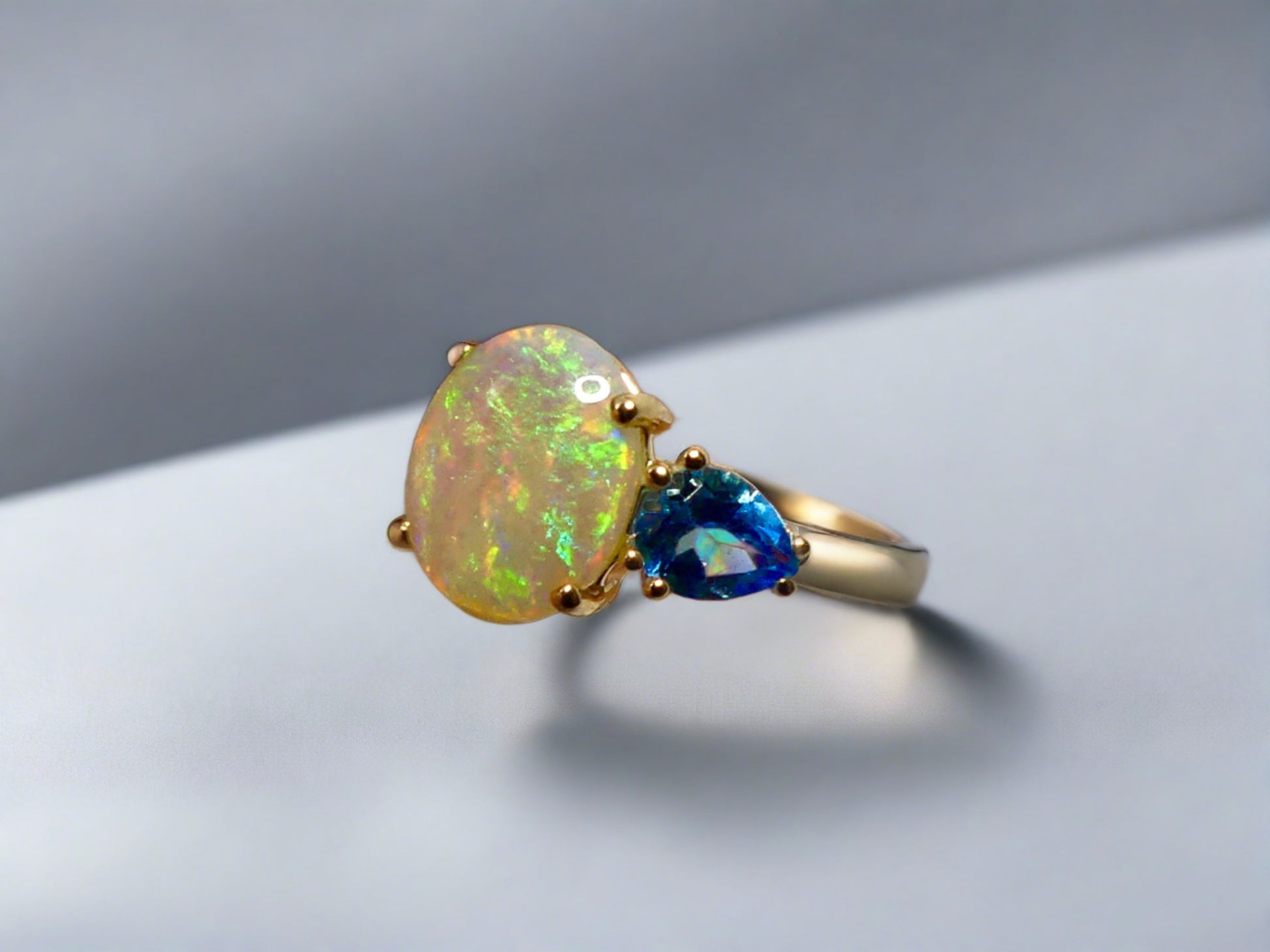 Introducing our stunning 14k Gold Australian Crystal Opal Ring. Ethically sourced from Lightning Ridge Australia, its mesmerizing play-of-color is unlike any other. Each piece is truly one-of-a-kind

Origin- Lightning Ridge Australia

Opal Weight- 1ct Australian Crystal Opal

Setting- 14k Claw Setting

Accent Stone- Swiss Blue Topaz

Ring Size- 6 1/2us.

Handcrafted with precision and passion by Australian Artisans.