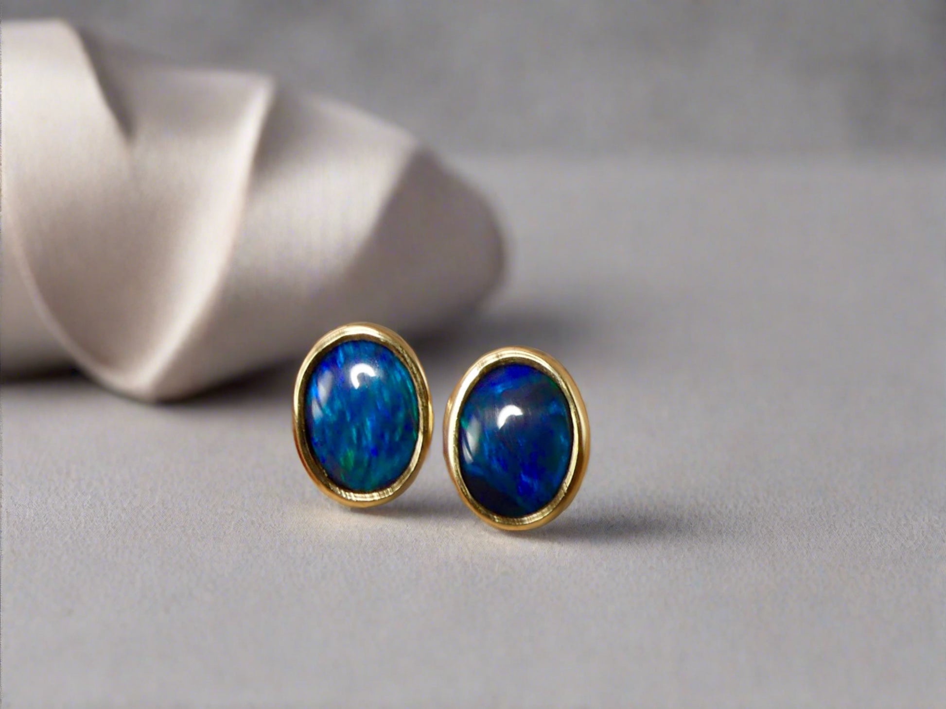Introducing our exquisite Australian Black Opal Stud Earrings, a captivating fusion of natural beauty and fine craftsmanship. Each earring features a mesmerizing Australian black opal, renowned for its rich play of colors and inherent elegance.

Origin- Lighting Ridge Australia

Opal Weight- Combined weight 2ct Australian Black Opal

Setting- 14k Gold Bezel set Stud Earrings&nbsp;

Size- 10 x 8mm

Designed by Australian Artisans with Elegance and sophistication in mind.