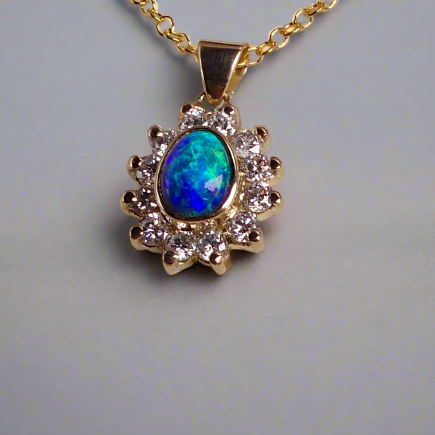 Experience the captivating allure of this handcrafted 18K Yellow Gold Opal &amp; Diamond Halo Pendant. With a striking Lightning Ridge opal showcasing a rare and sought-after script pattern consisting of blue, green, and gold tones, complemented by radiant diamonds, this necklace is a sophisticated and essential piece for any collection.

Origin- Lightning Ridge Australia

Opal Weight- 1ct Australian Lightning Ridge Semi Black Opal

Setting- 18k Yellow Gold Bezel set, claw set Diamond Halo