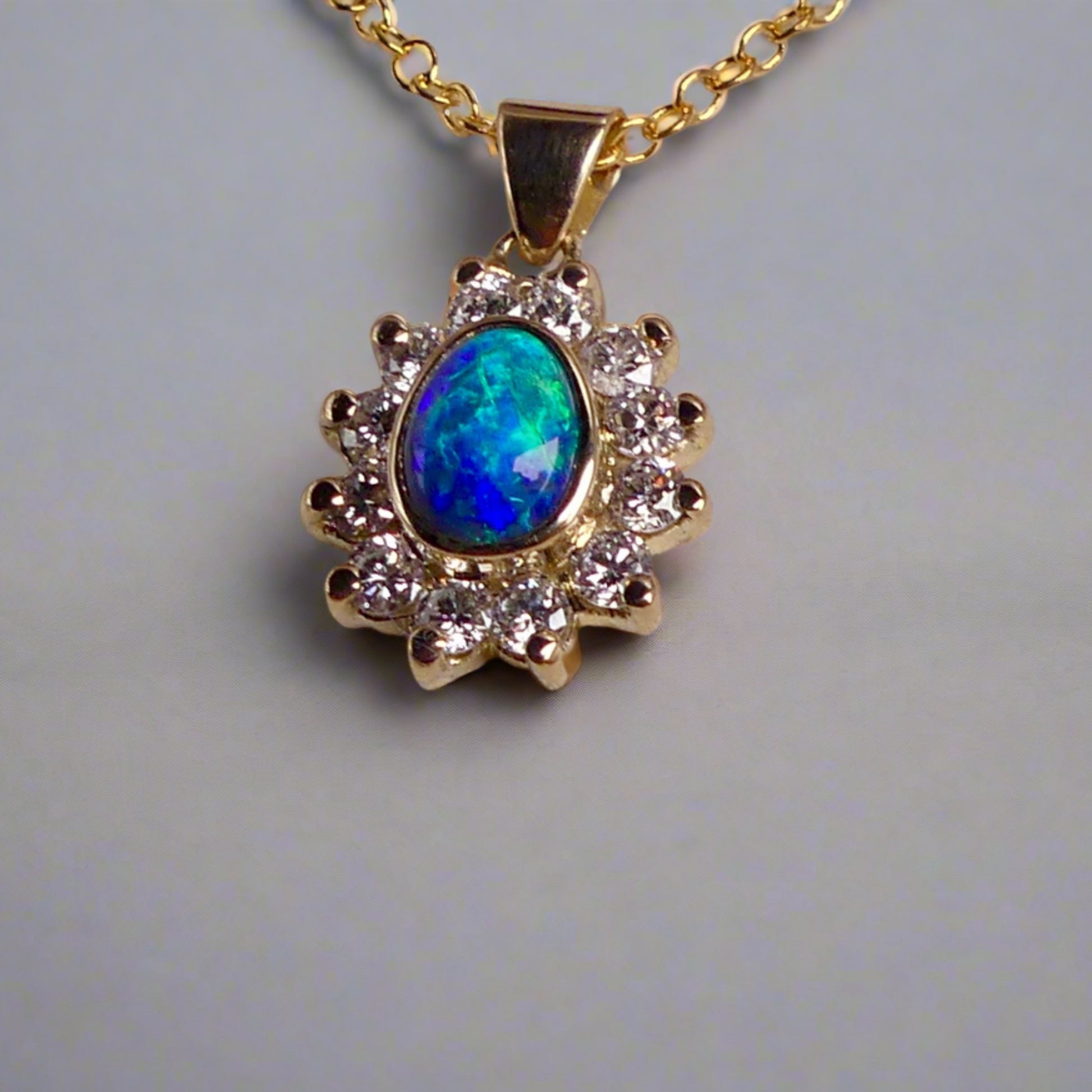 Experience the captivating allure of this handcrafted 18K Yellow Gold Opal &amp; Diamond Halo Pendant. With a striking Lightning Ridge opal showcasing a rare and sought-after script pattern consisting of blue, green, and gold tones, complemented by radiant diamonds, this necklace is a sophisticated and essential piece for any collection.

Origin- Lightning Ridge Australia

Opal Weight- 1ct Australian Lightning Ridge Semi Black Opal

Setting- 18k Yellow Gold Bezel set, claw set Diamond Halo