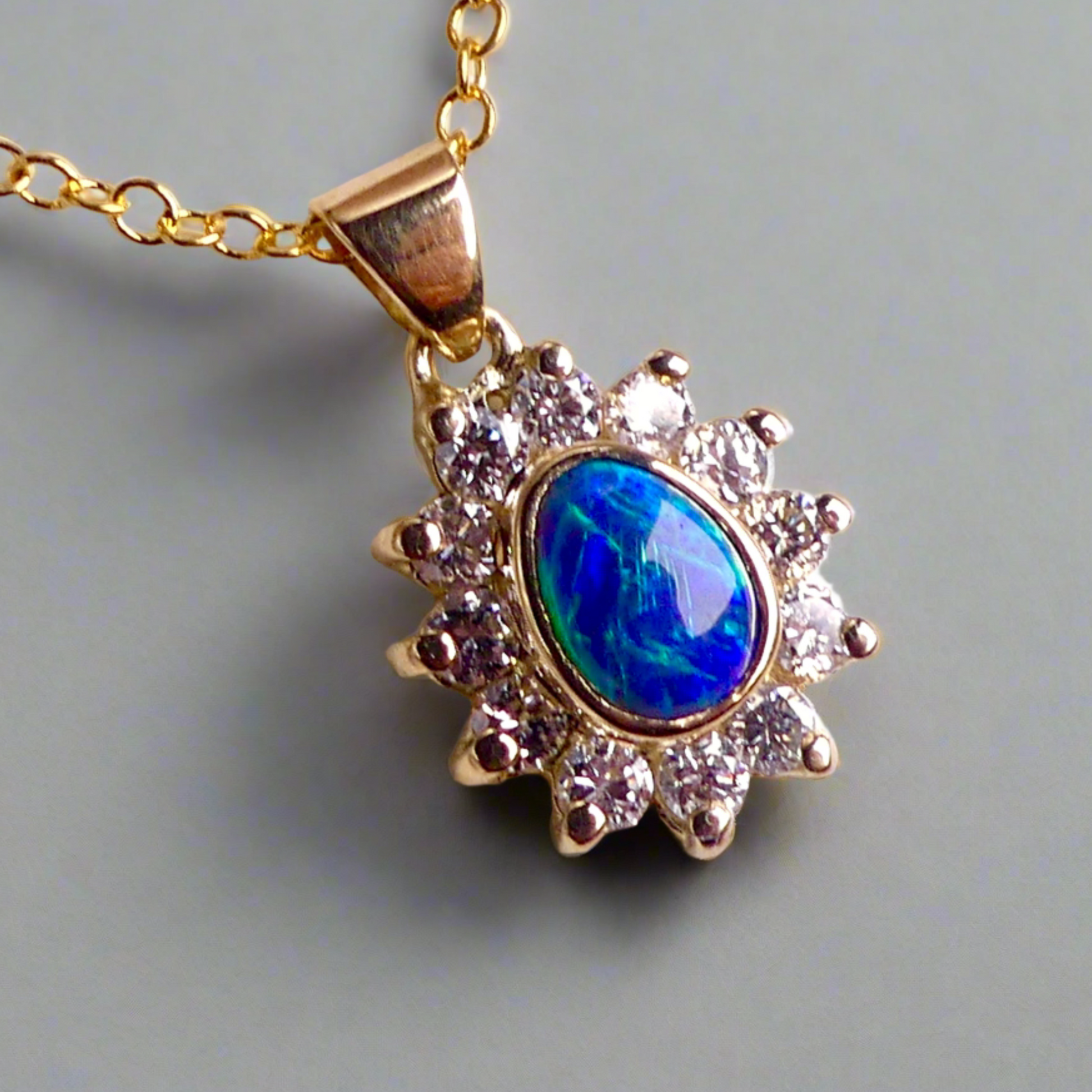Experience the captivating allure of this handcrafted 18K Yellow Gold Opal &amp; Diamond Halo Pendant. With a striking Lightning Ridge opal showcasing a rare and sought-after script pattern consisting of blue, green, and gold tones, complemented by radiant diamonds, this necklace is a sophisticated and essential piece for any collection.

Origin- Lightning Ridge Australia

Opal Weight- 1ct Australian Lightning Ridge Semi Black Opal

Setting- 18k Yellow Gold Bezel set, claw set Diamond Halo