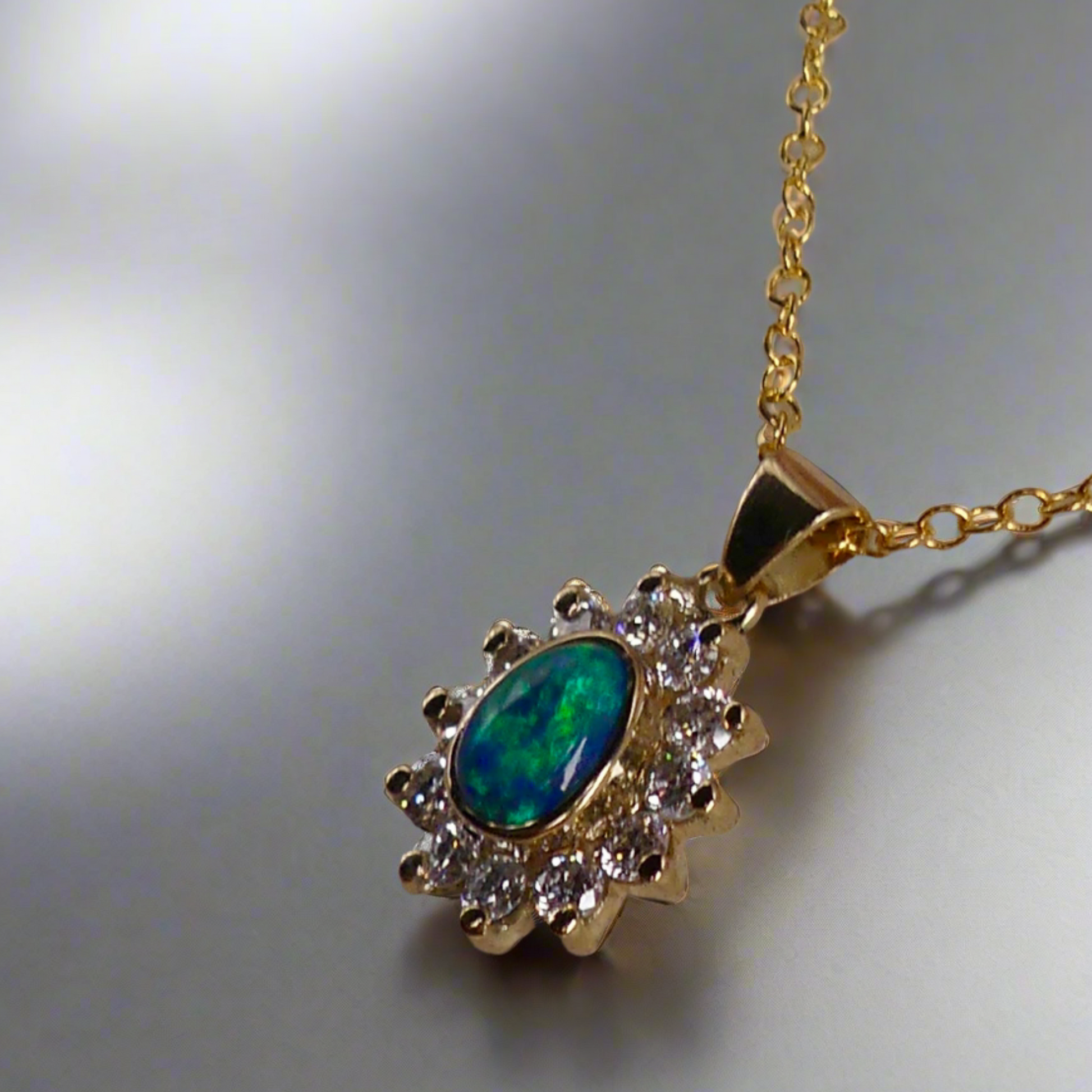 Experience the captivating allure of this handcrafted 18K Yellow Gold Opal &amp; Diamond Halo Pendant. With a striking Lightning Ridge opal showcasing a rare and sought-after script pattern consisting of blue, green, and gold tones, complemented by radiant diamonds, this necklace is a sophisticated and essential piece for any collection.

Origin- Lightning Ridge Australia

Opal Weight- 1ct Australian Lightning Ridge Semi Black Opal

Setting- 18k Yellow Gold Bezel set, claw set Diamond Halo