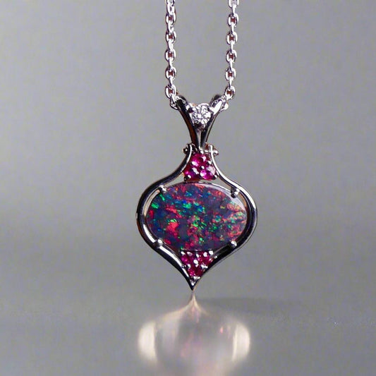 This stunning 18k white gold pendant features a rare and captivating Australian black opal accented with a brilliant center diamond and stunning rubies. Elevate your look with this breathtaking piece and indulge in the unique beauty and elegance of this precious gemstone.

Opal Weight- 1.6ct Australian Black Opal

Opal Origin- Lightning Ridge Australia

Setting- Rhodium Plated 18k White Gold

Accent Stones- Center Diamond, Rubies

Chain- 18k White Gold 45cm in length

