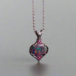 This stunning 18k white gold pendant features a rare and captivating Australian black opal accented with a brilliant center diamond and stunning rubies. Elevate your look with this breathtaking piece and indulge in the unique beauty and elegance of this precious gemstone.

Opal Weight- 1.6ct Australian Black Opal

Opal Origin- Lightning Ridge Australia

Setting- Rhodium Plated 18k White Gold

Accent Stones- Center Diamond, Rubies

Chain- 18k White Gold 45cm in length
