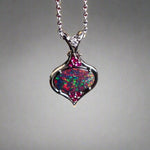 This stunning 18k white gold pendant features a rare and captivating Australian black opal accented with a brilliant center diamond and stunning rubies. Elevate your look with this breathtaking piece and indulge in the unique beauty and elegance of this precious gemstone.

Opal Weight- 1.6ct Australian Black Opal

Opal Origin- Lightning Ridge Australia

Setting- Rhodium Plated 18k White Gold

Accent Stones- Center Diamond, Rubies

Chain- 18k White Gold 45cm in length
