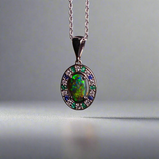 Lightning Ridge Australian black opal with strong, highly prized colors of reds, orange, and yellows is undoubtedly a remarkable gemstone. Expertly crafted from 18k white gold, this pendant showcases the mesmerizing beauty of an Australian black opal, surrounded by sparkling diamonds, emeralds, and sapphires. Exquisite in design and quality, this pendant is a luxurious addition to any jewelry collection. Elevate your style with this stunning piece.

Opal Weight- 1.1ct

Body Tone- N1 Australian Black