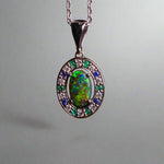 Lightning Ridge Australian black opal with strong, highly prized colors of reds, orange, and yellows is undoubtedly a remarkable gemstone. Expertly crafted from 18k white gold, this pendant showcases the mesmerizing beauty of an Australian black opal, surrounded by sparkling diamonds, emeralds, and sapphires. Exquisite in design and quality, this pendant is a luxurious addition to any jewelry collection. Elevate your style with this stunning piece.

Opal Weight- 1.1ct

Body Tone- N1 Australian Black