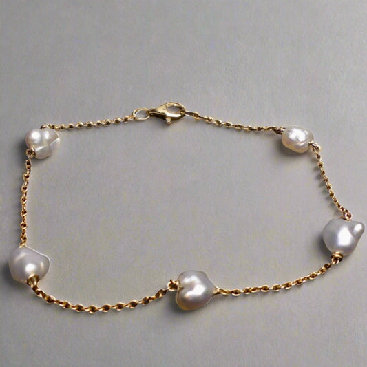 Expertly crafted with 9k gold and 5 Keshi pearls, our Elegant Keshi Pearl Bracelet exudes timeless sophistication. Each pearl's unique shape adds to the overall elegance of the piece, making it a perfect accessory for any occasion. Elevate your style with this exquisite bracelet.

Pearl- Keshi Saltwater Pearls

Setting- Handcrafted 9k Gold

Handcrafted By Australian Artisans