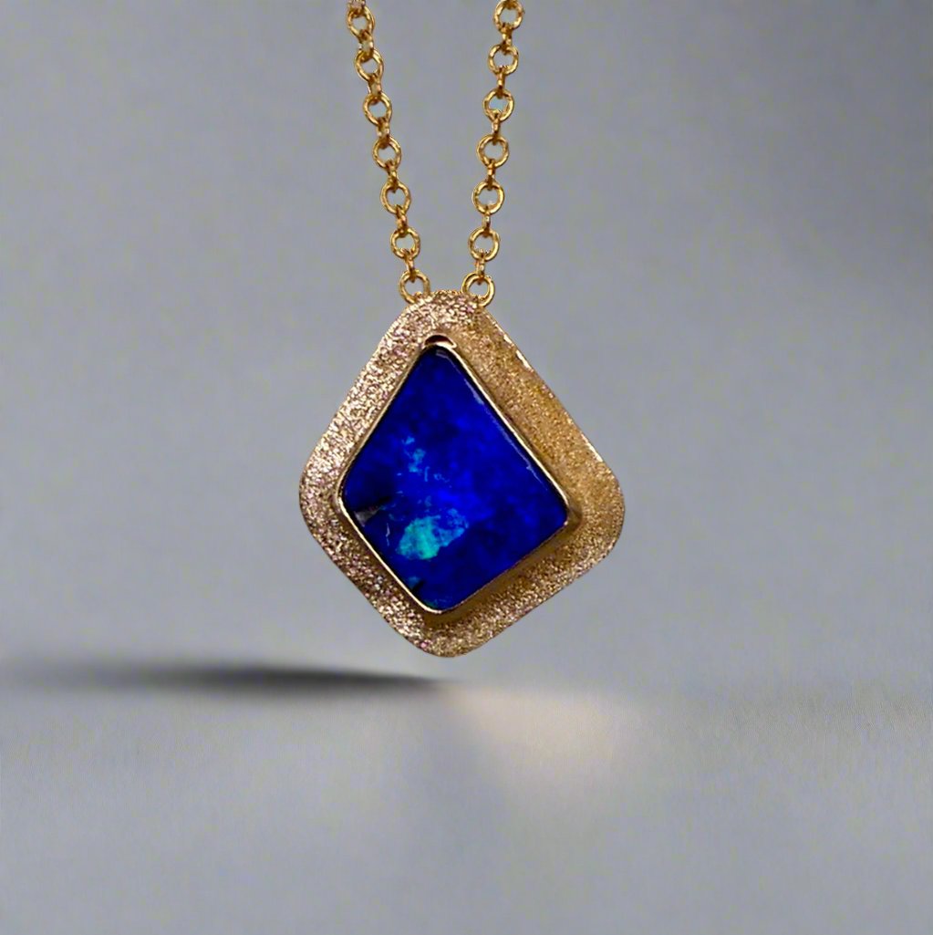 Expertly crafted, this Beautiful Australian Boulder Opal 18k Gold Pendant is a stunning piece of jewelry. Featuring a mesmerizing display of ocean blues and greens, this pendant is complemented by a solid 18k gold chain. Elevate any outfit with this unique and luxurious accessory.

Setting- 18k Gold bezel set

Opal Weight- 4.9ct

Origin- Queensland Australia

Chain- 18k gold cable chan, 45cm in Length

Expertly Handcrafted By Australian Artisans

