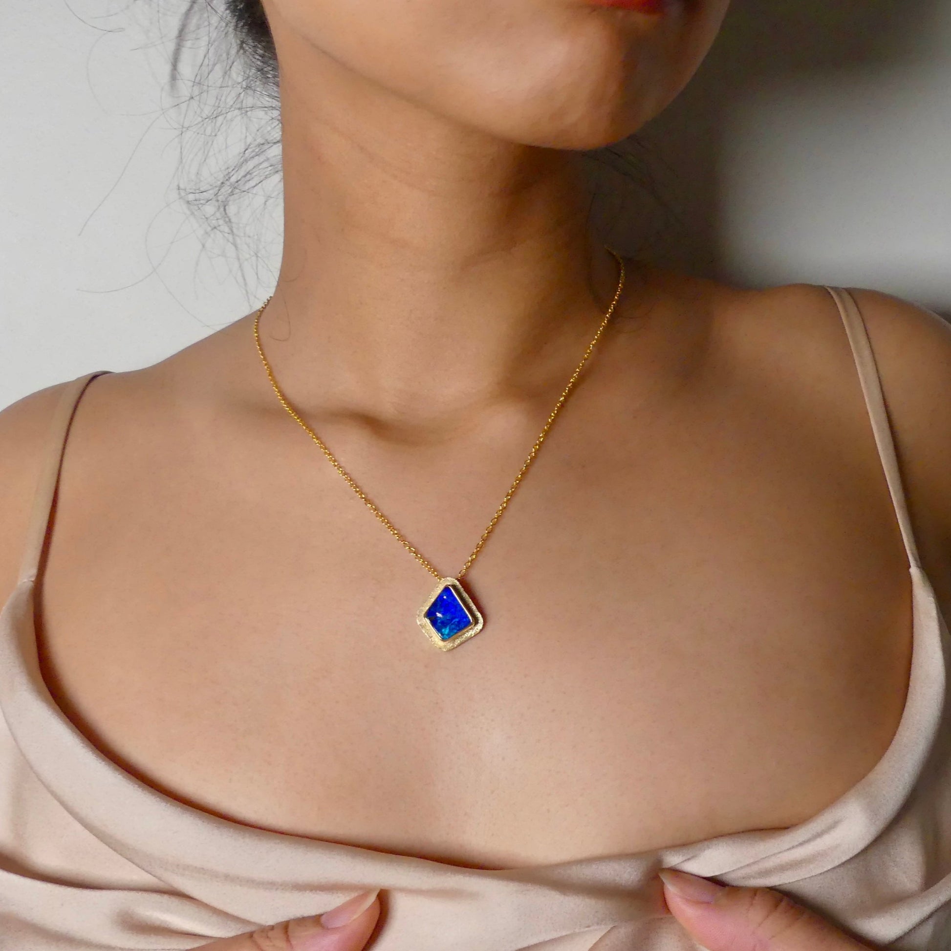 Expertly crafted, this Beautiful Australian Boulder Opal 18k Gold Pendant is a stunning piece of jewelry. Featuring a mesmerizing display of ocean blues and greens, this pendant is complemented by a solid 18k gold chain. Elevate any outfit with this unique and luxurious accessory.

Setting- 18k Gold bezel set

Opal Weight- 4.9ct

Origin- Queensland Australia

Chain- 18k gold cable chan, 45cm in Length

Expertly Handcrafted By Australian Artisans
