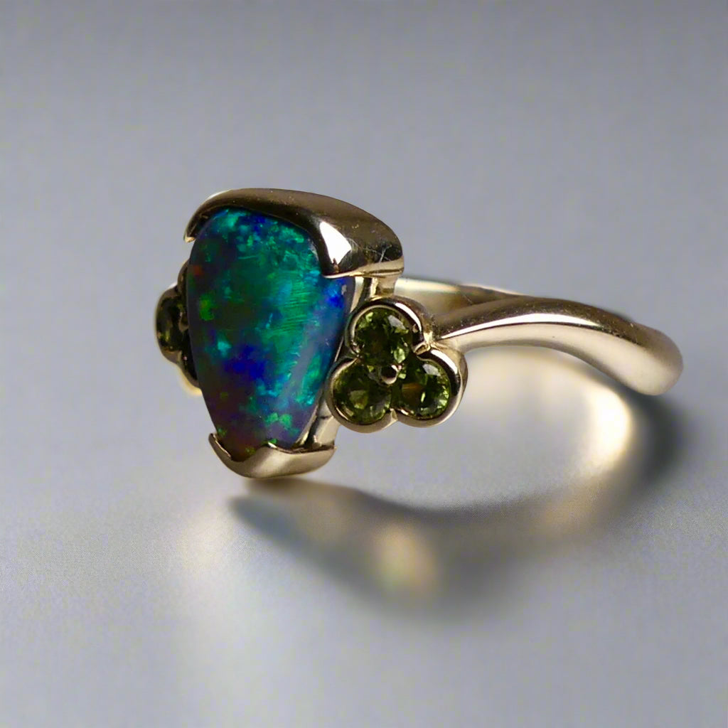Indulge in timeless elegance with our 14k Australian Black Opal Ring. Crafted with a stunning black opal, this ring showcases mesmerizing blue and green colors. Each piece is unique, making it the perfect addition to any jewelry collection. Elevate your style with this timeless and luxurious ring.

Opal- 1.6ct Australian Black Opal

Origin-Lightning Ridge Australia

Setting- 14k Yellow Gold Bezel Set

Accent Stones- Forrest Green Sapphires

Size- 7 1/4 us
