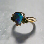 Indulge in timeless elegance with our 14k Australian Black Opal Ring. Crafted with a stunning black opal, this ring showcases mesmerizing blue and green colors. Each piece is unique, making it the perfect addition to any jewelry collection. Elevate your style with this timeless and luxurious ring.

Opal- 1.6ct Australian Black Opal

Origin-Lightning Ridge Australia

Setting- 14k Yellow Gold Bezel Set

Accent Stones- Forrest Green Sapphires

Size- 7 1/4 us
