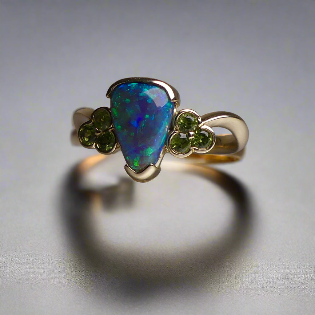 Indulge in timeless elegance with our 14k Australian Black Opal Ring. Crafted with a stunning black opal, this ring showcases mesmerizing blue and green colors. Each piece is unique, making it the perfect addition to any jewelry collection. Elevate your style with this timeless and luxurious ring.

Opal- 1.6ct Australian Black Opal

Origin-Lightning Ridge Australia

Setting- 14k Yellow Gold Bezel Set

Accent Stones- Forrest Green Sapphires

Size- 7 1/4 us
