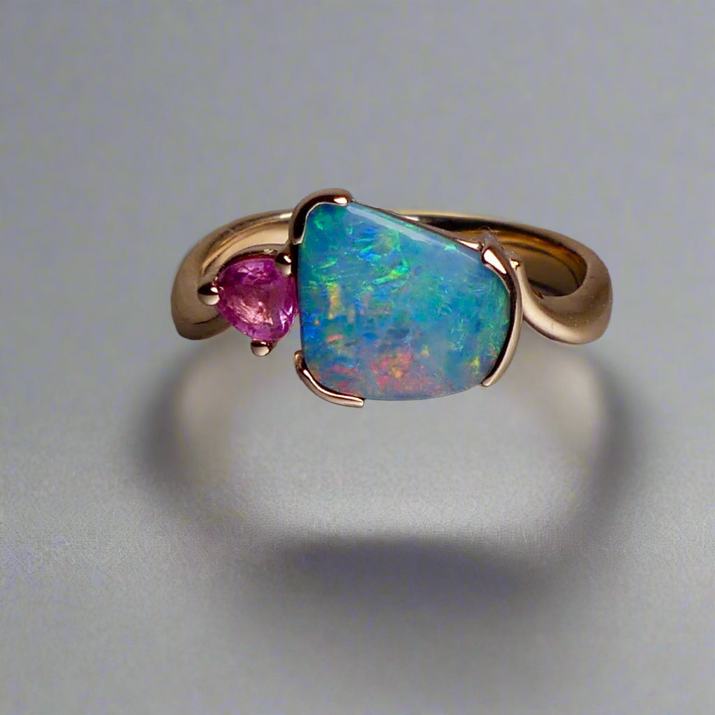 Indulge in luxury with our Elegant 9k Gold Australian Boulder Opal Ring. This opulent piece displays a mesmerizing array of colors, making it a true statement of elegance. Handcrafted with the finest materials, this ring exudes sophistication and exclusivity. Elevate your style and add a touch of opulence to any outfit.

Opal- 2ct Australian Boulder Opal

Origin- Queensland Australia

Setting- 9k Gold Bezel Set

Accent Stone- Pink Tourmaline

Size- 7 1/2