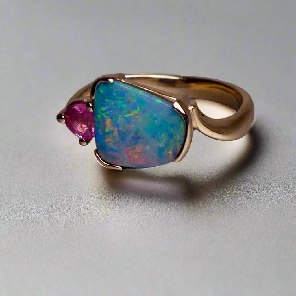Indulge in luxury with our Elegant 9k Gold Australian Boulder Opal Ring. This opulent piece displays a mesmerizing array of colors, making it a true statement of elegance. Handcrafted with the finest materials, this ring exudes sophistication and exclusivity. Elevate your style and add a touch of opulence to any outfit.

Opal- 2ct Australian Boulder Opal

Origin- Queensland Australia

Setting- 9k Gold Bezel Set

Accent Stone- Pink Tourmaline

Size- 7 1/2