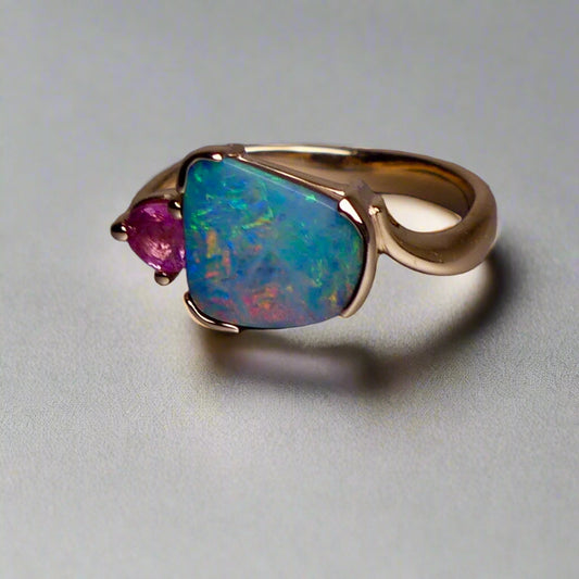 Indulge in luxury with our Elegant 9k Gold Australian Boulder Opal Ring. This opulent piece displays a mesmerizing array of colors, making it a true statement of elegance. Handcrafted with the finest materials, this ring exudes sophistication and exclusivity. Elevate your style and add a touch of opulence to any outfit.

Opal- 2ct Australian Boulder Opal

Origin- Queensland Australia

Setting- 9k Gold Bezel Set

Accent Stone- Pink Tourmaline

Size- 7 1/2