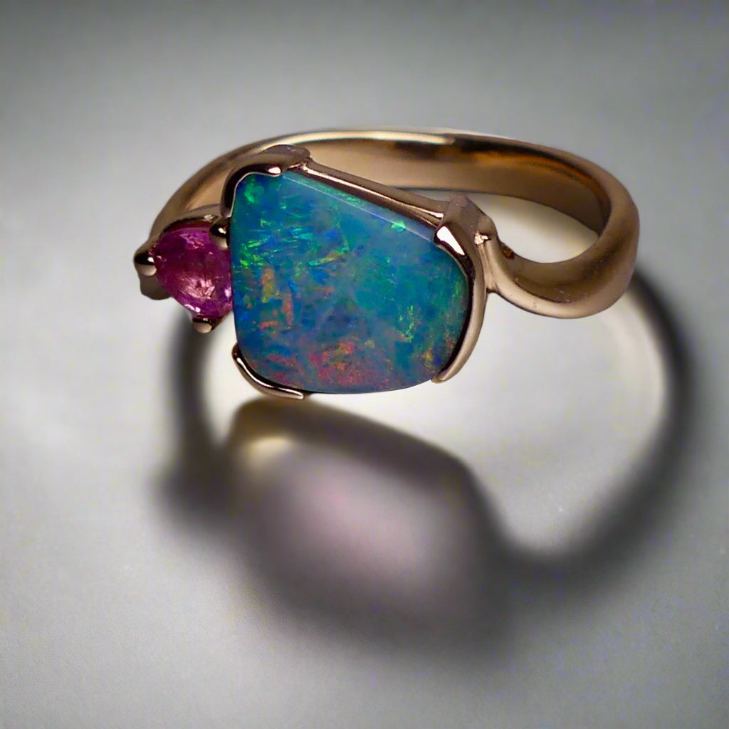 Indulge in luxury with our Elegant 9k Gold Australian Boulder Opal Ring. This opulent piece displays a mesmerizing array of colors, making it a true statement of elegance. Handcrafted with the finest materials, this ring exudes sophistication and exclusivity. Elevate your style and add a touch of opulence to any outfit.

Opal- 2ct Australian Boulder Opal

Origin- Queensland Australia

Setting- 9k Gold Bezel Set

Accent Stone- Pink Tourmaline

Size- 7 1/2