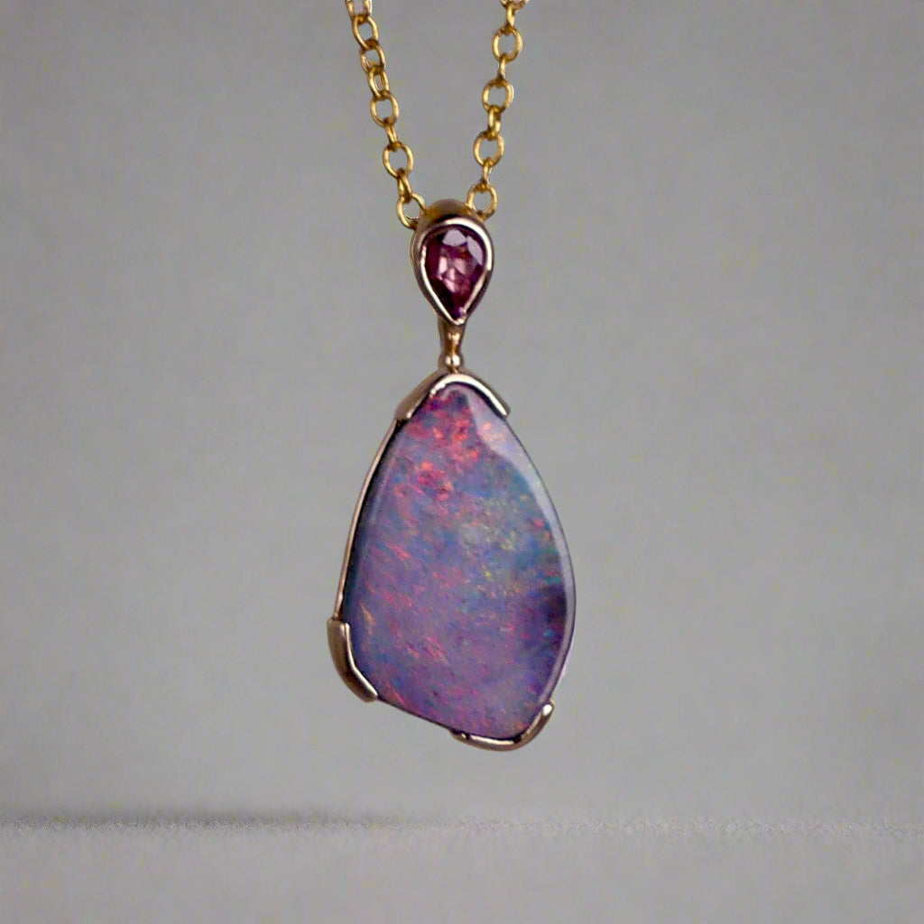 Add a touch of elegance to your jewelry collection with this stunning 9k gold Australian boulder opal pendant. The mesmerizing colors of the opal create a unique and beautiful piece that will surely turn heads. Perfect for everyday wear or special occasions, this pendant is a must-have for any opal lover. A timeless accessory that will elevate any outfit effortlessly.

Opal- 6.75ct Australian Boulder Opal

Origin- Queensland Australia

Setting- 9k Gold Bezel Set

Accent Stone- Pink Sapphire
