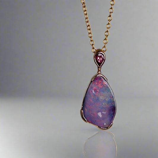 Add a touch of elegance to your jewelry collection with this stunning 9k gold Australian boulder opal pendant. The mesmerizing colors of the opal create a unique and beautiful piece that will surely turn heads. Perfect for everyday wear or special occasions, this pendant is a must-have for any opal lover. A timeless accessory that will elevate any outfit effortlessly.

Opal- 6.75ct Australian Boulder Opal

Origin- Queensland Australia

Setting- 9k Gold Bezel Set

Accent Stone- Pink Sapphire

